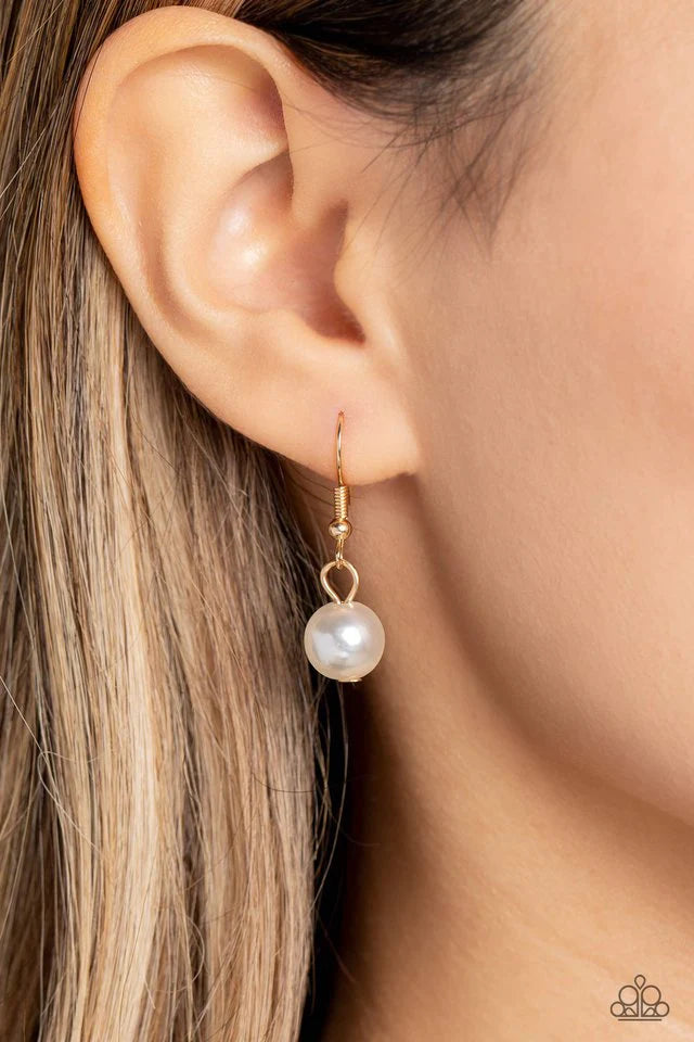 Paparazzi Accessories Countess Chic - Gold Strung along the entirety of an invisible wire, classic white pearls in varying sizes coalesce down the neckline for a refined finish. Adding to the elegant design, a sparkly white rhinestone-encrusted gold ornam