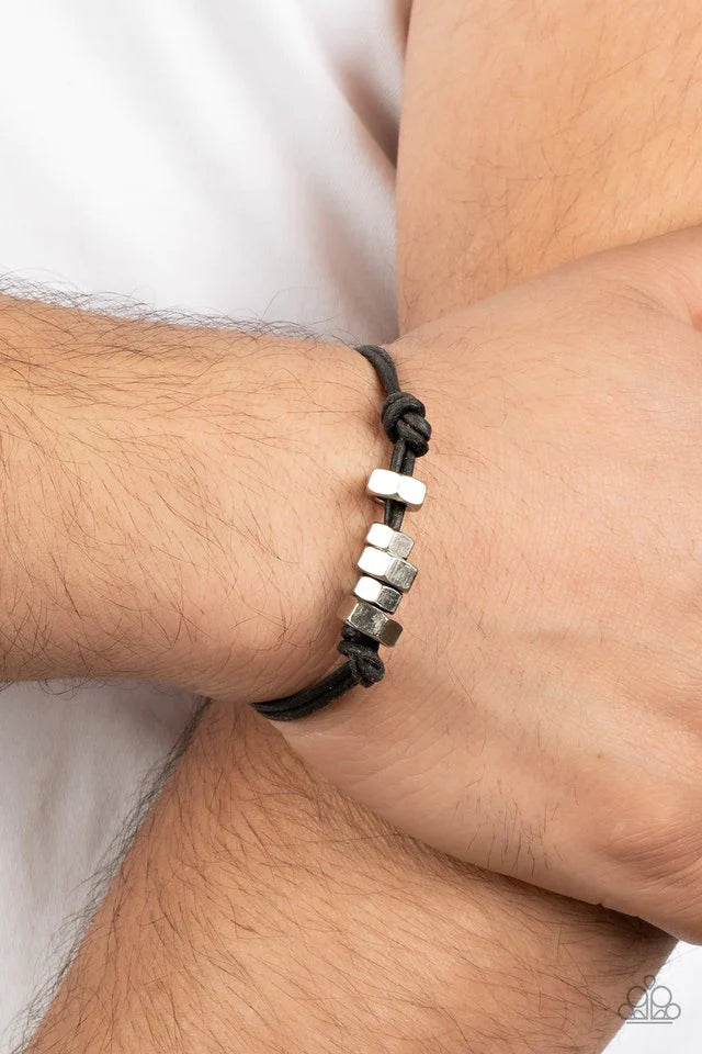 Paparazzi Accessories Bolt Out - Black A row of silver hexagonal hardware is knotted in place along black suede cording around the wrist, creating an edgy urban look. Features an adjustable sliding knot closure. Jewelry