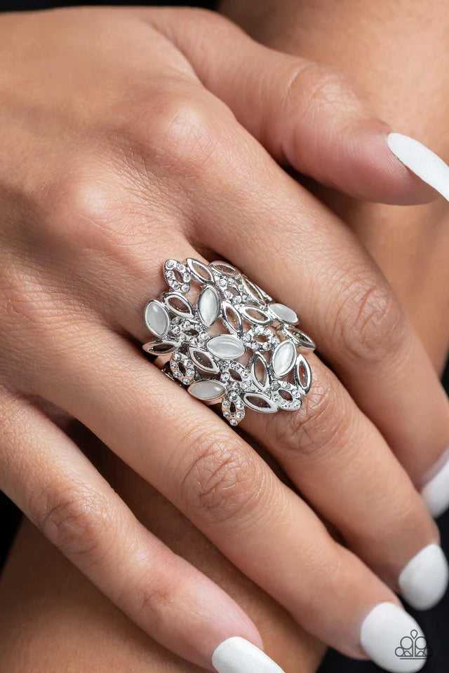 Paparazzi Accessories LEAF Home - White A gorgeous cascade of silver, white rhinestone-encrusted, and white cat's eye marquise-cut frames fan out across the finger, coalescing into an airy, whimsical statement. Features a stretchy band for a flexible fit.