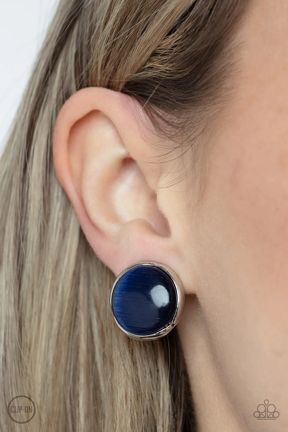 Paparazzi Accessories Cool Pools - Blue *Clip-On A blue cat's eye stone coolly shimmers inside an imperfect silver frame, resulting in an ethereal centerpiece. Earring attaches to a standard clip-on fitting. Sold as one pair of clip-on earrings. Jewelry