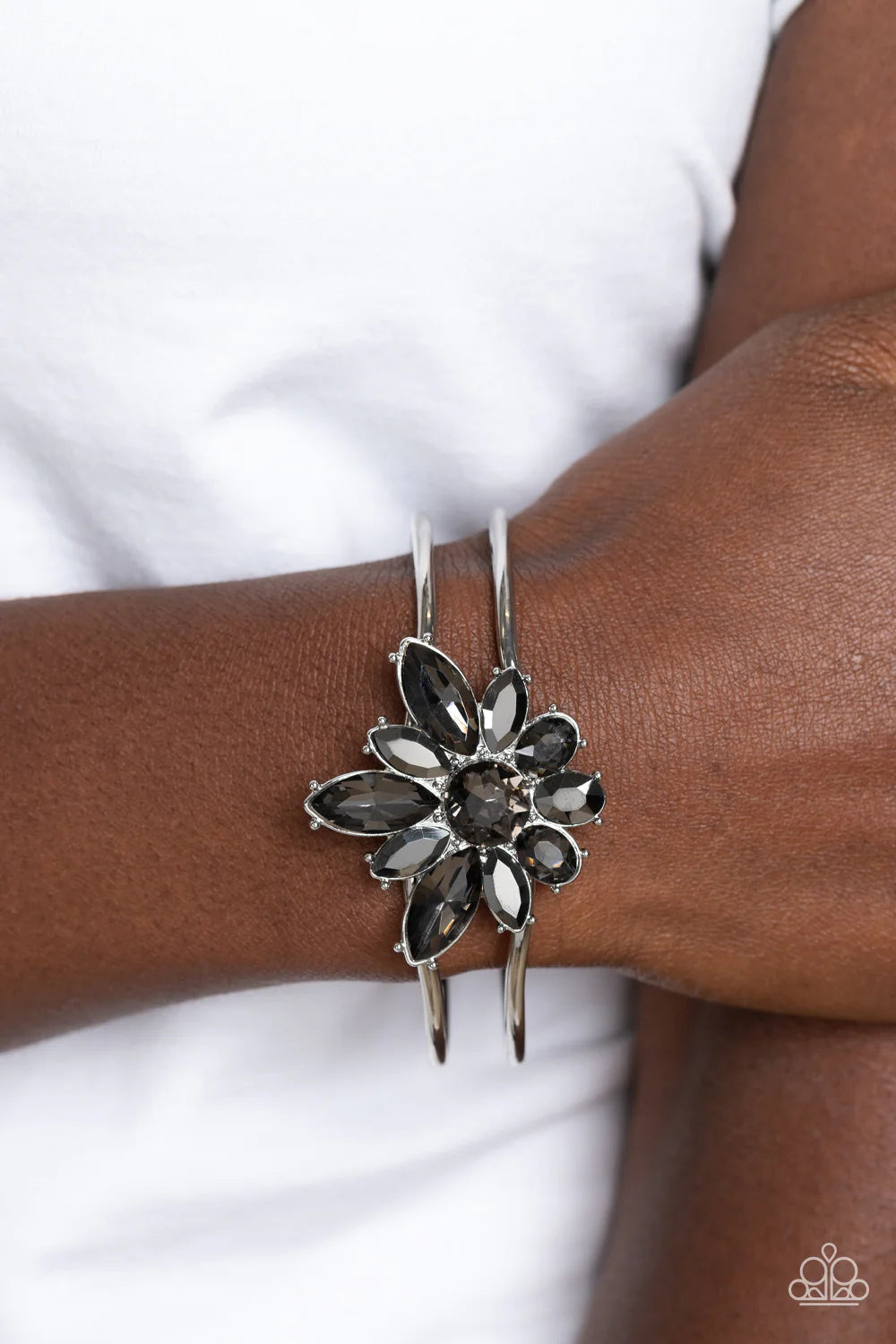 Paparazzi Accessories Chic Corsage - Silver Varying sizes of oval and marquise-cut gems in hematite and smoky shades bloom around a round-brilliant cut center in a similar smoky hue. The dazzling collection of sparkly petals coalesces into a stunning flor