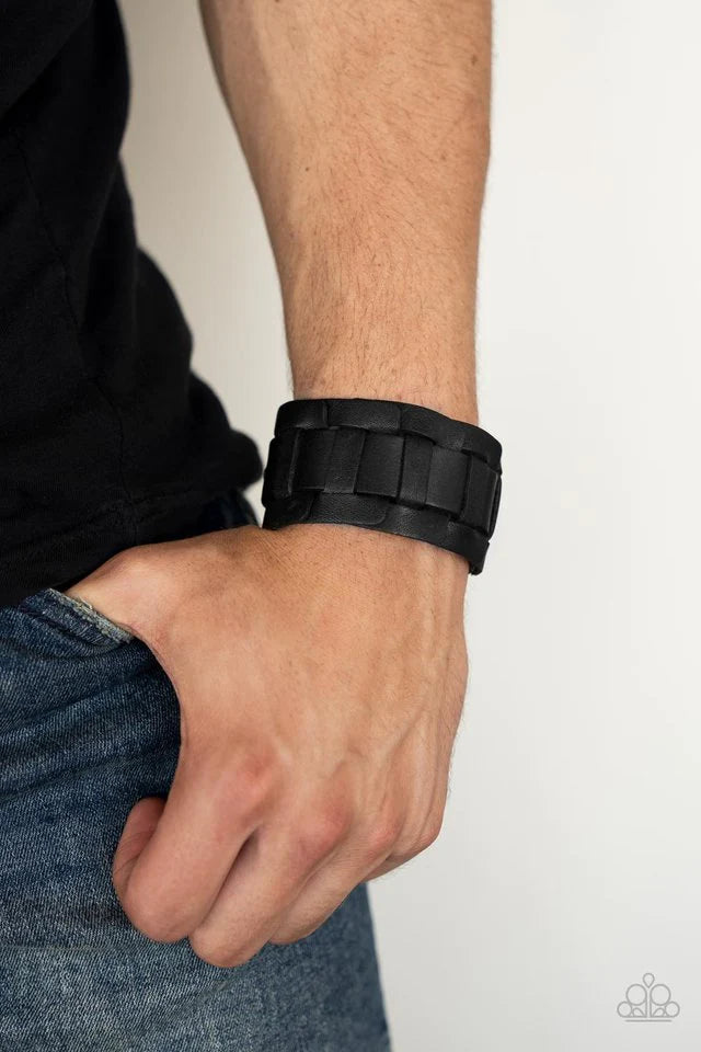 Paparazzi Accessories Plainly Plaited - Black A black leather band is threaded through the center of interlocking square leather links, creating a plaited pattern around the wrist. Features an adjustable snap closure. Sold as one individual bracelet. Jewe