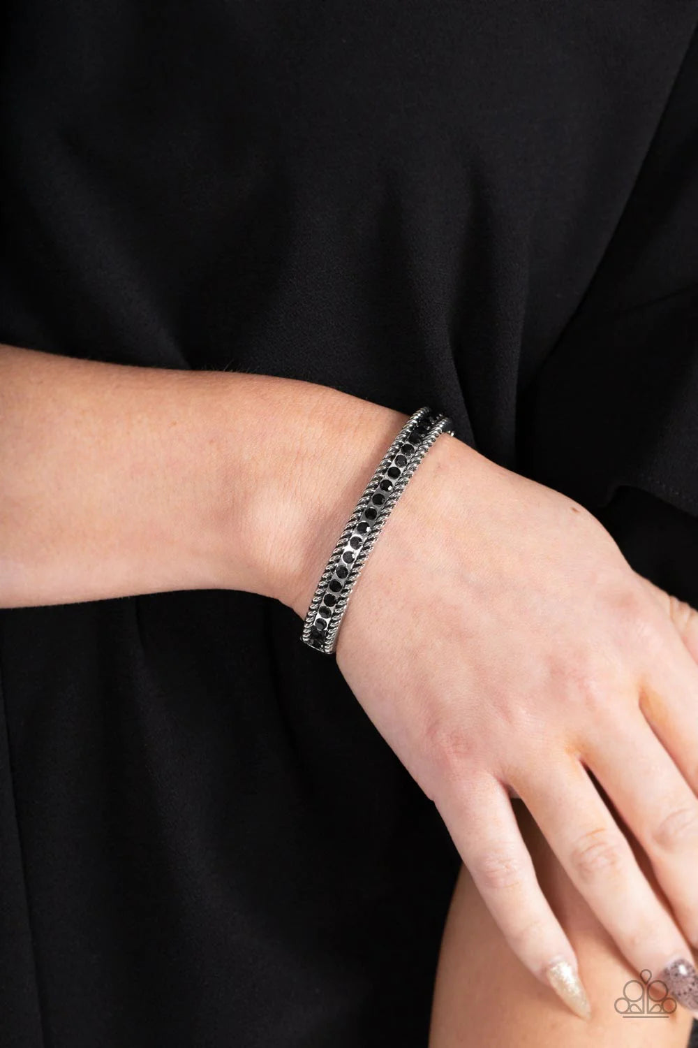 Paparazzi Accessories Rebel Renaissance - Black Gritty silver rope-like borders flank a glitzy row of black rhinestones, creating a smoldering bangle-like bracelet around the wrist. Features a hinged closure. Sold as one individual bracelet. Jewelry