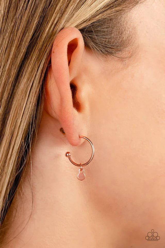 Paparazzi Accessories Modern Model - Copper A small, skinny, shiny copper hoop curves around the ear in a timeless fashion. A shiny copper ball is affixed to the end of the hoop, reminiscent of a barbell fitting. A dainty shiny copper disc slides along th