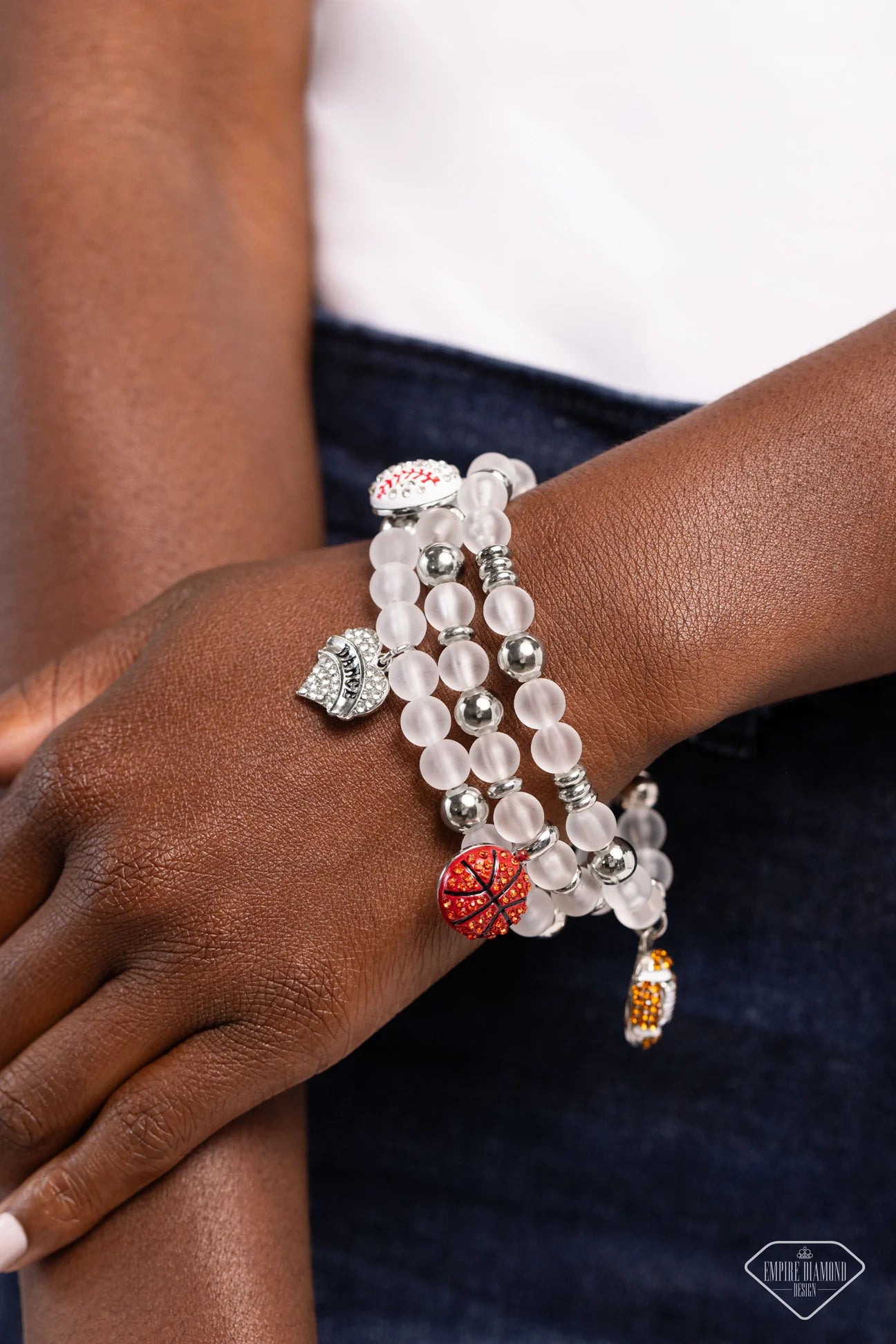 Paparazzi Accessories Sports Fan - Multi A mismatched assortment of various rhinestone-encrusted sports balls and a "DANCE"-stamped rhinestone heart, silver accents, and white glass-like beads are threaded along stretchy bands around the wrist, creating a