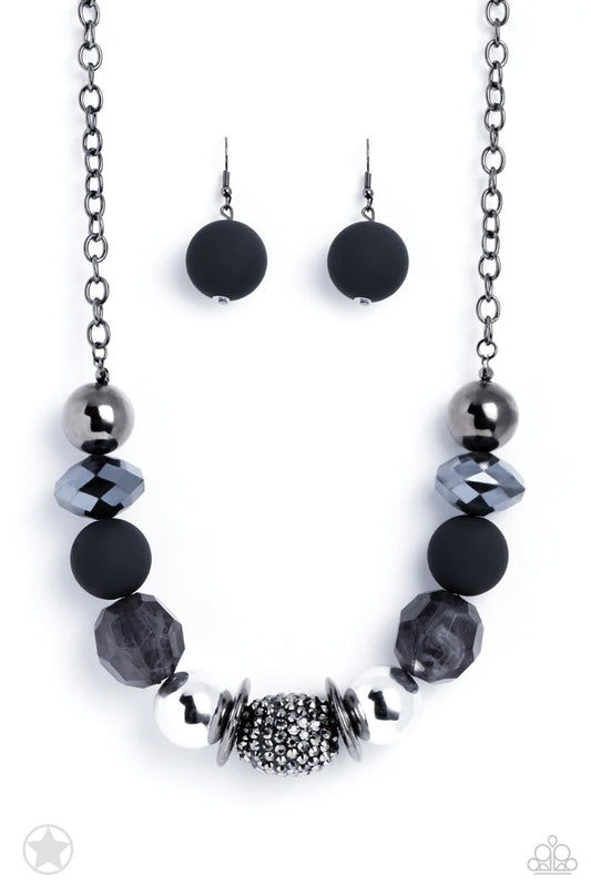 Paparazzi Accessories A Warm Welcome - Black Sophisticated beads in shades of gunmetal and black with reflective faceted edges and varying glazed finishes are offset by two shiny silver beads. An oblong bead studded with gunmetal rhinestones adds a dramat
