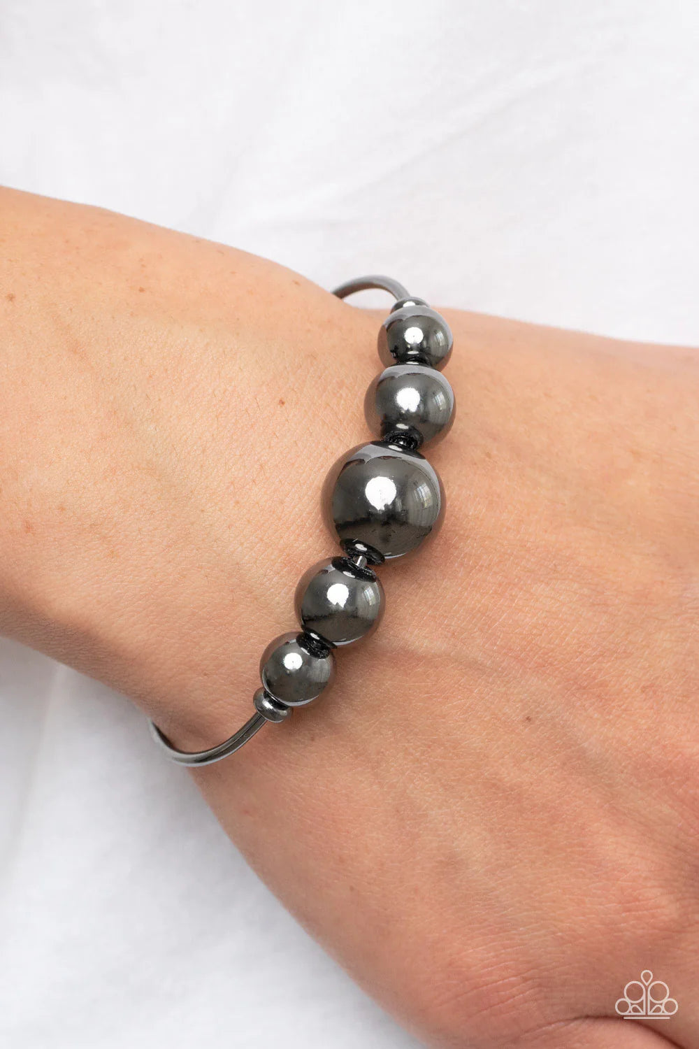 Paparazzi Accessories Bead Creed - Black Gradually increasing in size, an oversized collection of gunmetal beads are threaded along a dainty gunmetal cuff for a dramatic industrial display. Sold as one individual bracelet. Jewelry