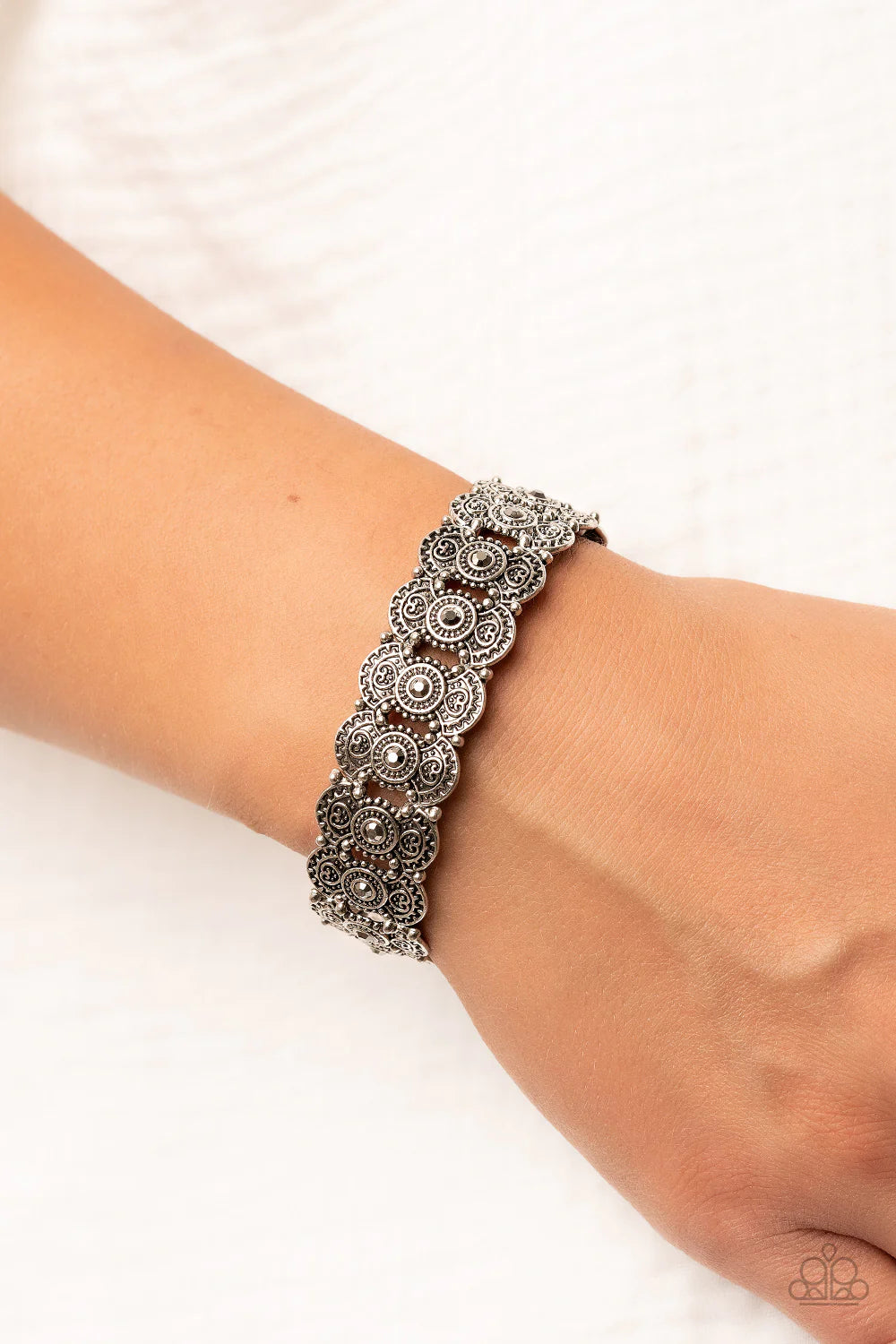 Paparazzi Accessories Rapturous Romance -Silver Dotted with smoky hematite rhinestones, pairs of studded and heart embossed patterned silver frames are threaded along stretchy bands around the wrist for a romantic fashion. Sold as one individual bracelet.