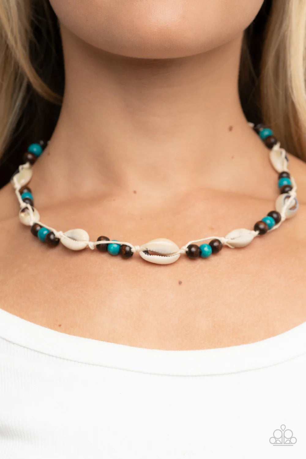 Paparazzi Accessories Bermuda Beachcomber - Blue Dainty white cowrie seashells alternate with sections of brown and blue wooden beads along knotted white cords, resulting in a beach inspired palette below the collar. Features a button loop closure. Sold a