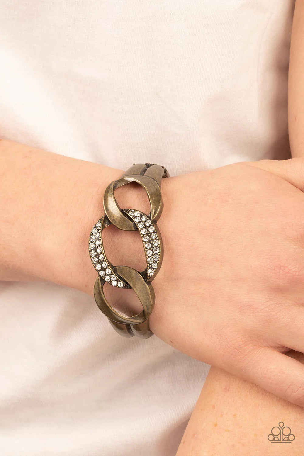 Paparazzi Accessories BOMBSHELL Squad - Brass A trio of rounded square brass links, featuring a hammered texture, interlock into an unapologetic display. The centermost link is dotted with glassy rhinestones, creating a sparkly fashion around the wrist. F