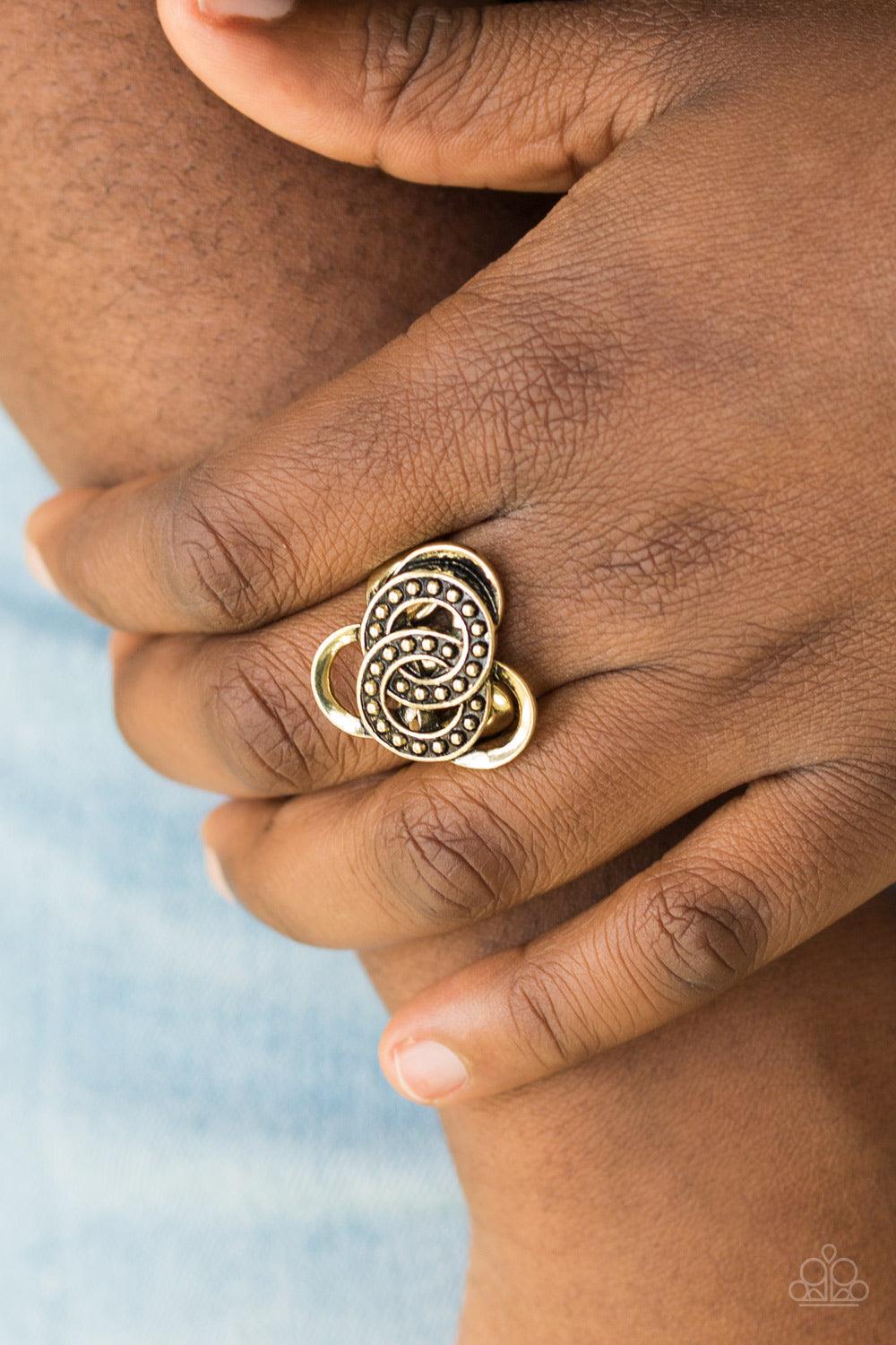 Paparazzi Accessories Dizzying Distraction - Brass Dotted in shimmery brass studs, antiqued rings sit atop a dizzying brass backdrop for an edgy geometric look. Features a dainty stretchy band for a flexible fit. Sold as one individual ring. Jewelry