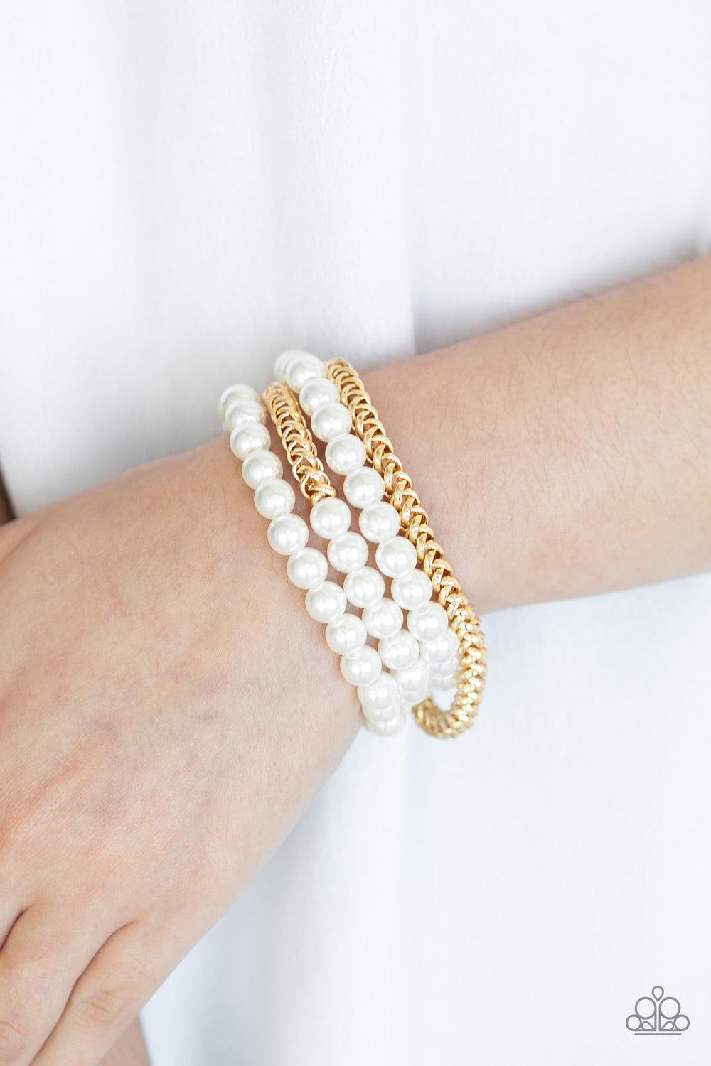 Paparazzi Accessories Industrial Incognito - Gold A collection of pearly white beads and glistening gold chains are threaded along stretchy bands, creating a bold collision of industrial glamour. Sold as one set of four bracelets. Jewelry