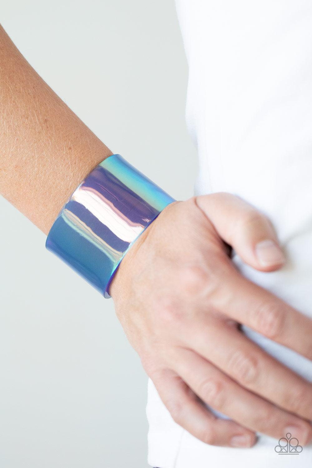 Paparazzi Accessories Holographic Aura - Blue Featuring a holographic shimmer, a thick blue acrylic cuff wraps around the wrist for a retro inspired fashion. Sold as one individual bracelet. Jewelry