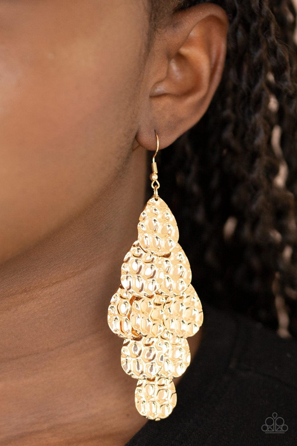 Paparazzi Accessories Instant Incandescence - Gold Featuring metallic honeycomb-like patterns, glistening gold teardrop frames cascade from the ear, coalescing into a noise-making lure. Earring attaches to a standard fishhook fitting. Sold as one pair of