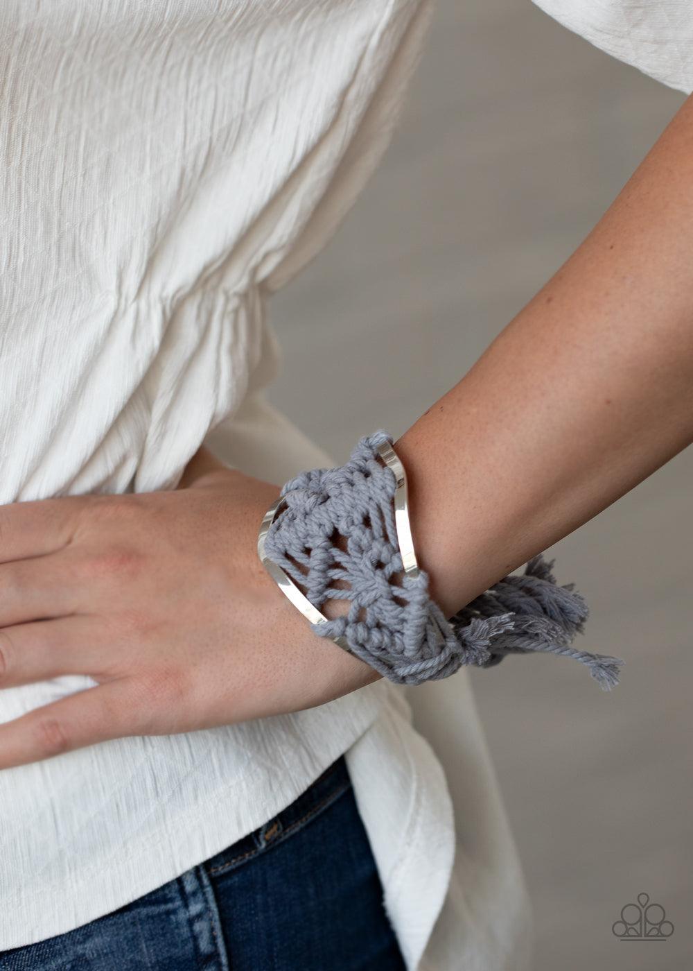 Paparazzi Accessories Macrame Mode - Silver Ash cording decoratively knots and weaves around an airy silver cuff for a macramé inspired look. Knotted around the ends, Ash tassels flair out from the bottoms of the cuff for a wanderlust finish. Sold as one