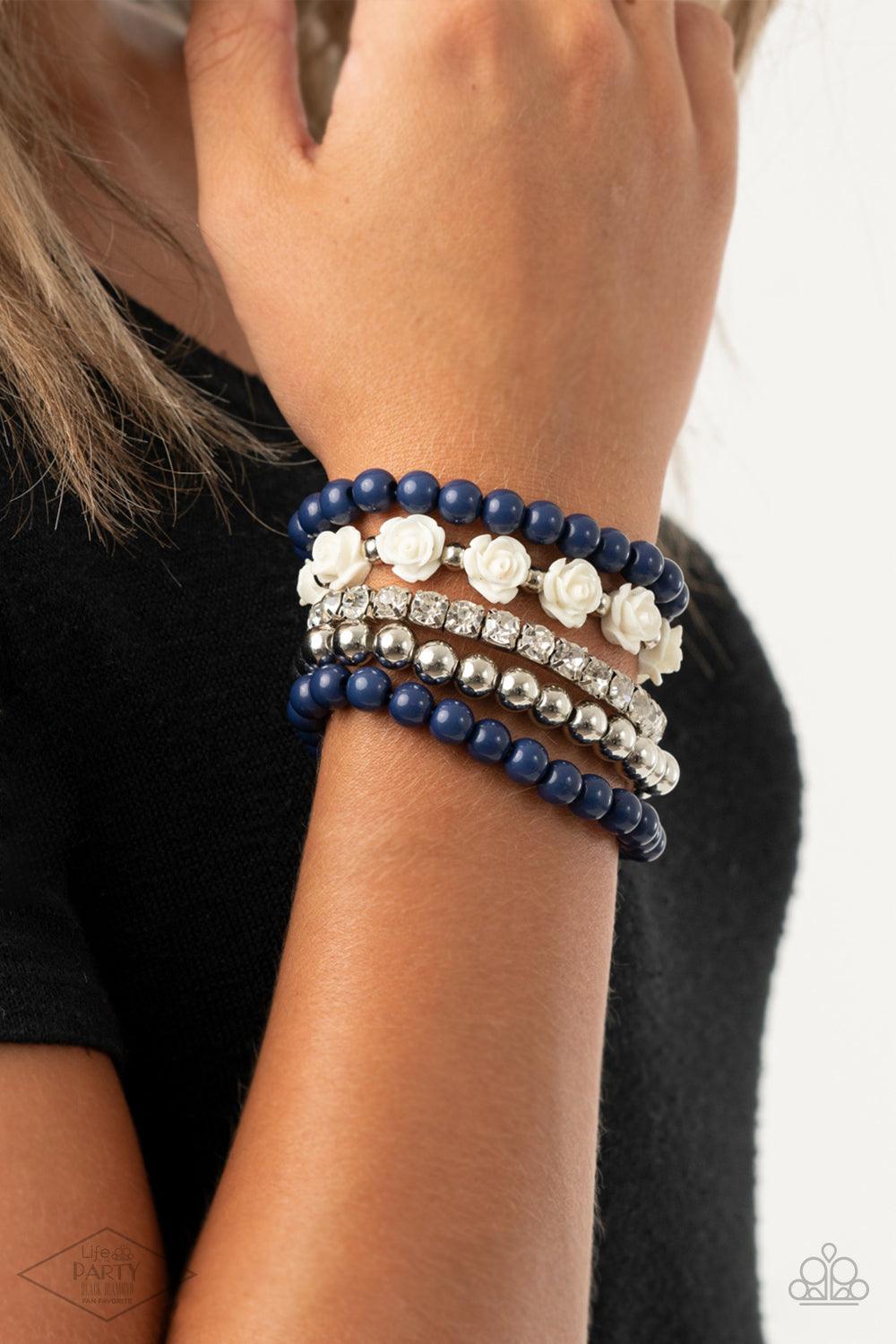 Paparazzi Accessories Rose Garden Grandeur - Blue A vintage inspired collection of ivory resin roses, navy beads, and classic silver beads join a stretchy band of glittery white rhinestones dotted around the wrist for a flawlessly stacked look. Sold as on