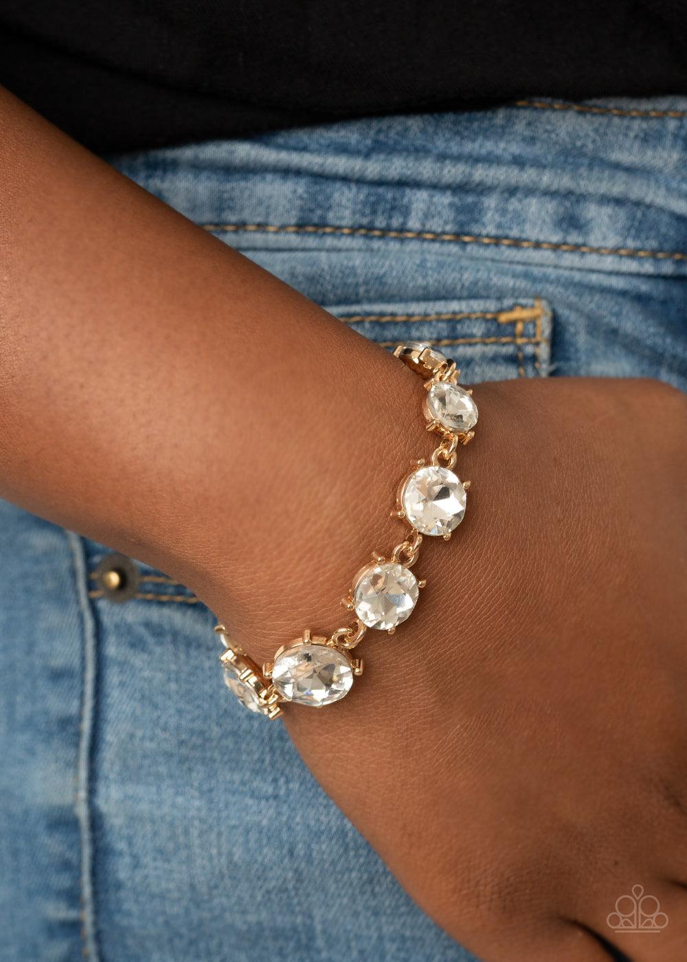 Paparazzi Accessories Cant Believe My ICE - Gold Gradually increasing in size at the center, a dramatic row of exaggerated white rhinestone encrusted gold frames delicately link around the wrist for a statement-making sparkle. Features an adjustable clasp