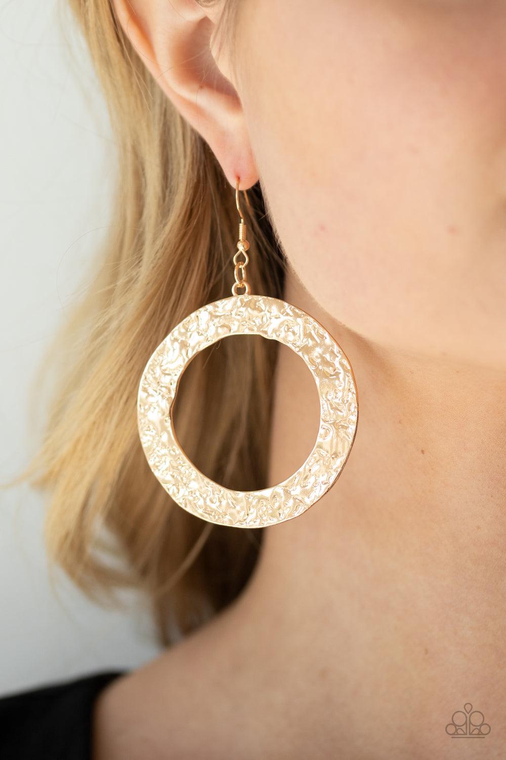Paparazzi Accessories PRIMAL Meridian - Gold A flat gold circular frame has been hammered in blinding detail for a handcrafted look. Earring attaches to a standard fishhook fitting. Sold as one pair of earrings. Jewelry