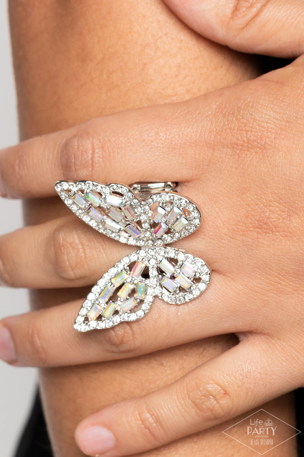 Paparazzi Accessories Flauntable Flutter - Multi Dainty iridescent emerald style rhinestones are sprinkled across the wings of a silver butterfly that is encrusted in glassy white rhinestones for a dramatically dazzling finish. Features a stretchy band fo
