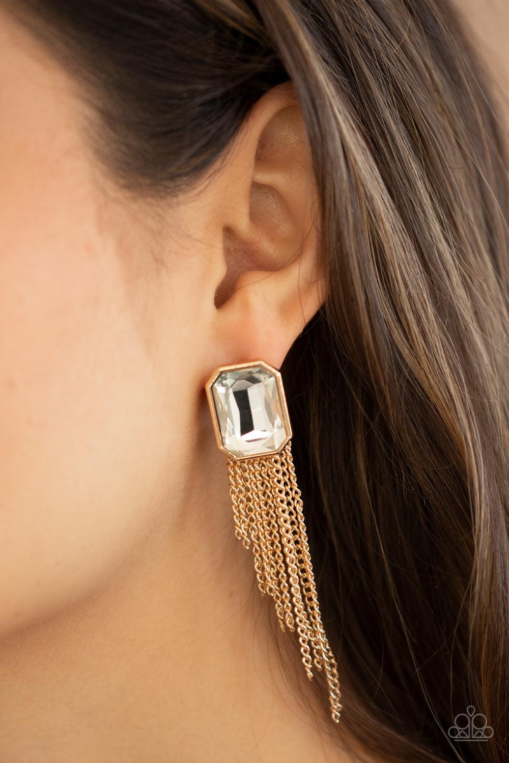 Paparazzi Accessories Save for a REIGNy Day - Gold Tapered gold chains stream from the bottom of an oversized white emerald cut gem, creating a regal fringe. Earring attaches to a standard post fitting. Sold as one pair of double-sided post earrings. Jewe