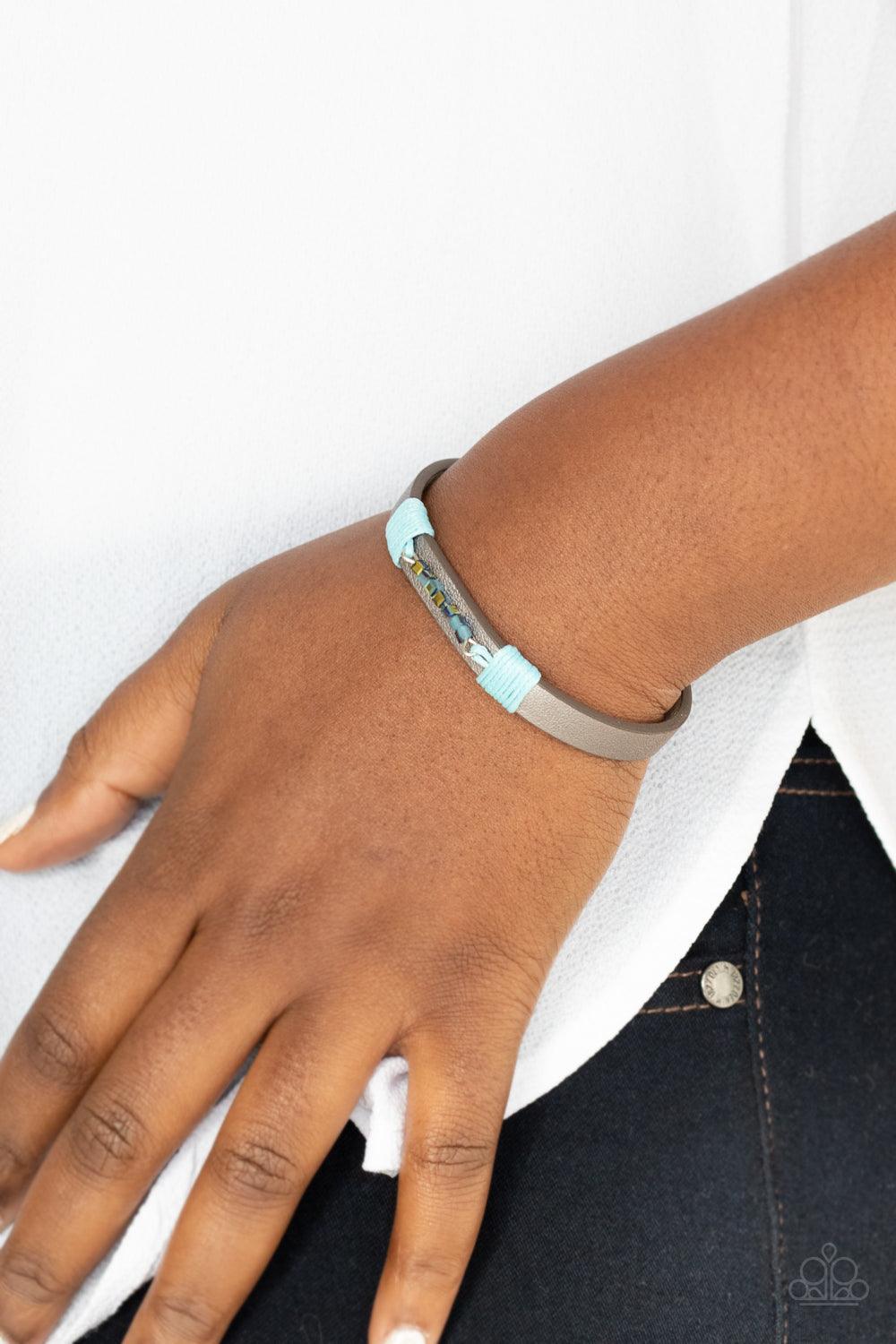 Paparazzi Accessories Worth The Hype - Blue Threaded along a dainty rod, a row of metallic and iridescent blue cube beads are knotted in place across the center of a silvery leather band. Features an adjustable snap closure. Sold as one individual bracele