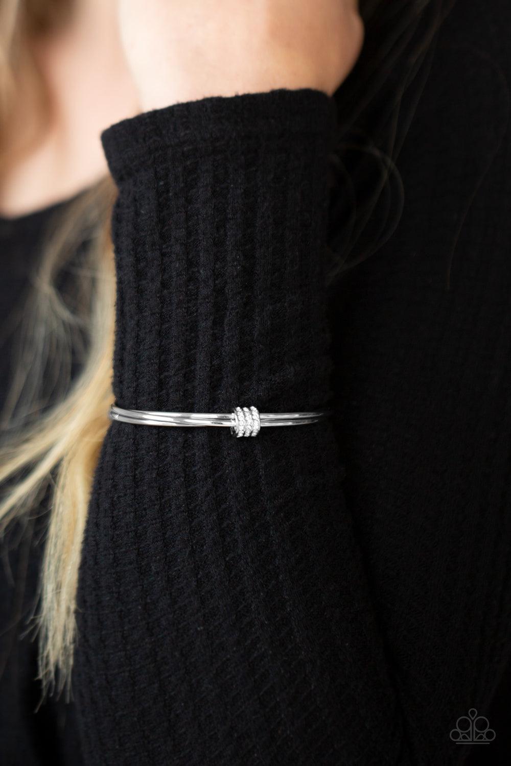 Paparazzi Accessories Roll Out The Rhinestones - White A white rhinestone encrusted fitting glides along a trio of silver bangles, creating a solitaire bracelet around the wrist. Sold as one individual bracelet. Jewelry