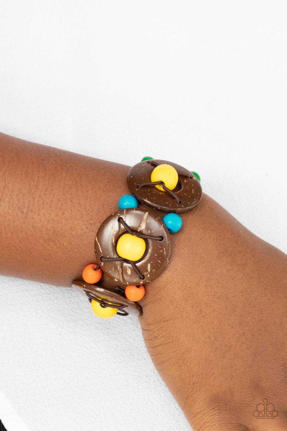 Paparazzi Accessories Island Adventure - Multi An oversized collection of multicolored beads and distressed brown wooden discs are threaded along stretchy bands that decoratively weave around the wrist for a summery flair. Sold as one individual bracelet.