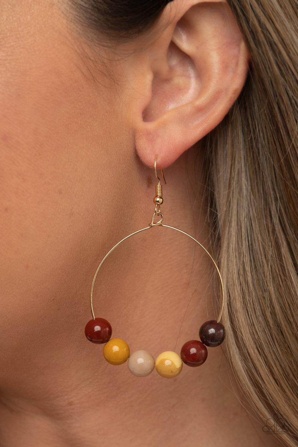 Paparazzi Accessories Let It Slide - Multi An oversized collection of earthy stones slide along the bottom of a dainty gold hoop, creating an earthy centerpiece. Earring attaches to a standard fishhook fitting. Sold as one pair of earrings. Jewelry