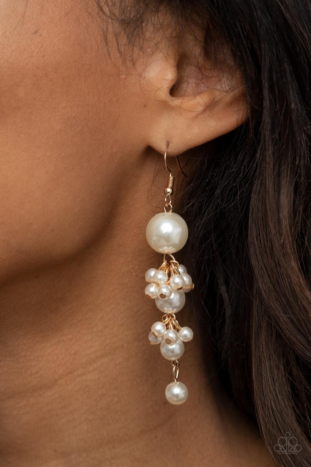Paparazzi Accessories Ageless Applique - Gold Clusters of dainty white pearls trickle along a glistening gold chain that delicately links together a bubbly strand of pearls. The classic pearls gradually decrease in size, creating a timelessly tasseled dis