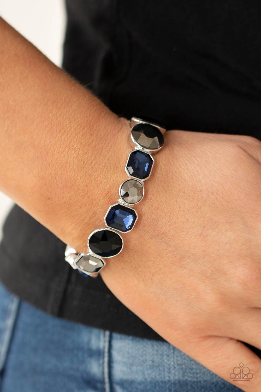 Paparazzi Accessories Extra Exposure - Multi Encased in sleek silver frames, a smoldering collection of round and emerald cut black, blue, and hematite rhinestones glide along stretchy bands around the wrist, creating a sparkly industrial statement piece.