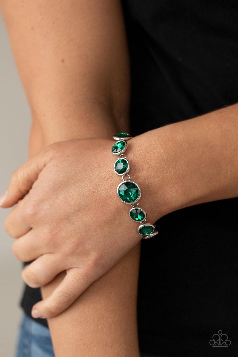 Paparazzi Accessories Lustrous Luminosity - Green Featuring sleek silver fittings, an oversized collection of sparkly green gems delicately link around the wrist. The centermost gem is slightly larger than the rest, adding a glamorous finish. Features an