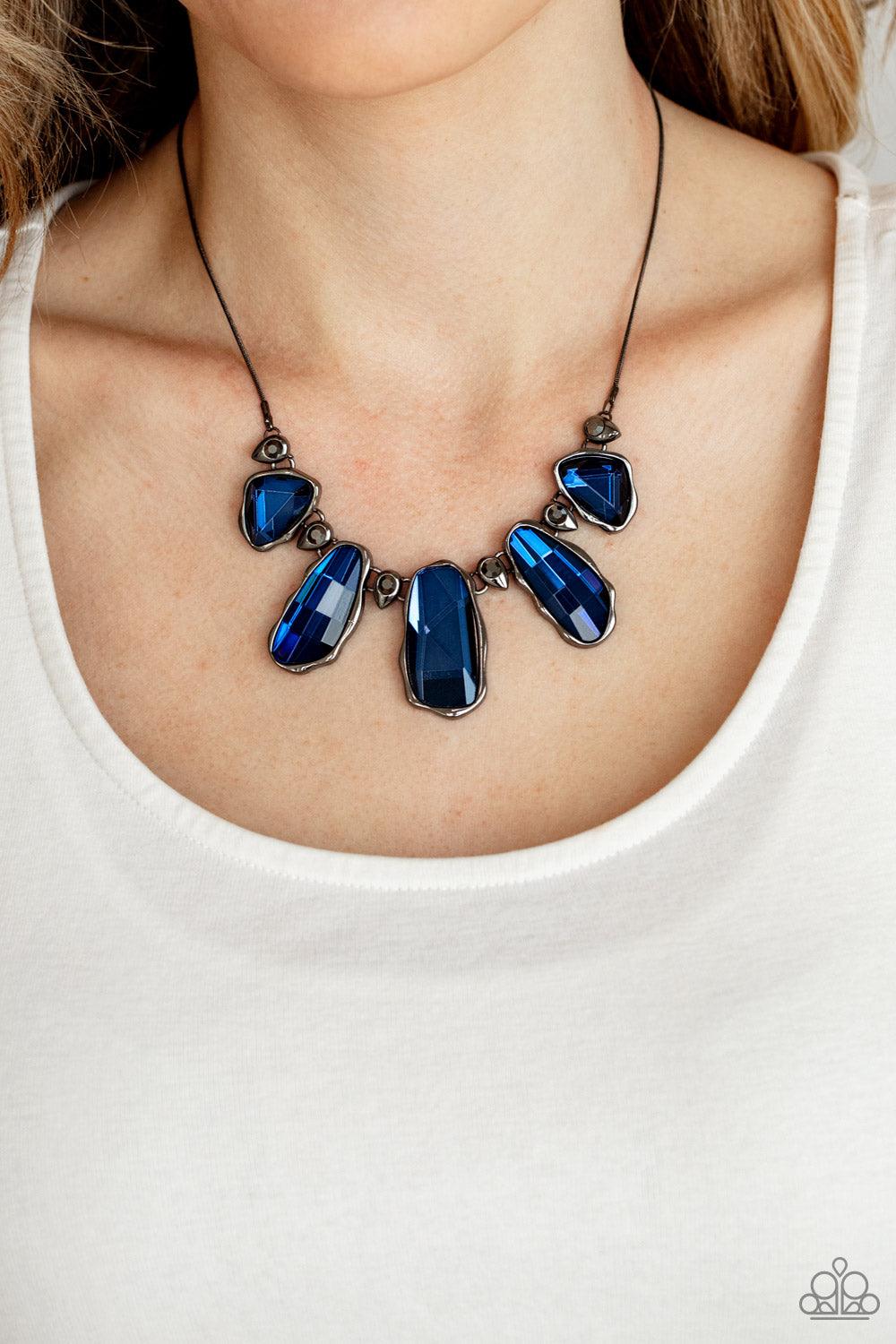 Paparazzi Accessories Cosmic Cocktail - Blue A glittery collection of raw cut blue gems delicately link with dainty hematite rhinestone dotted gunmetal teardrops below the collar, creating a stellar fringe. Features an adjustable clasp closure. Sold as on