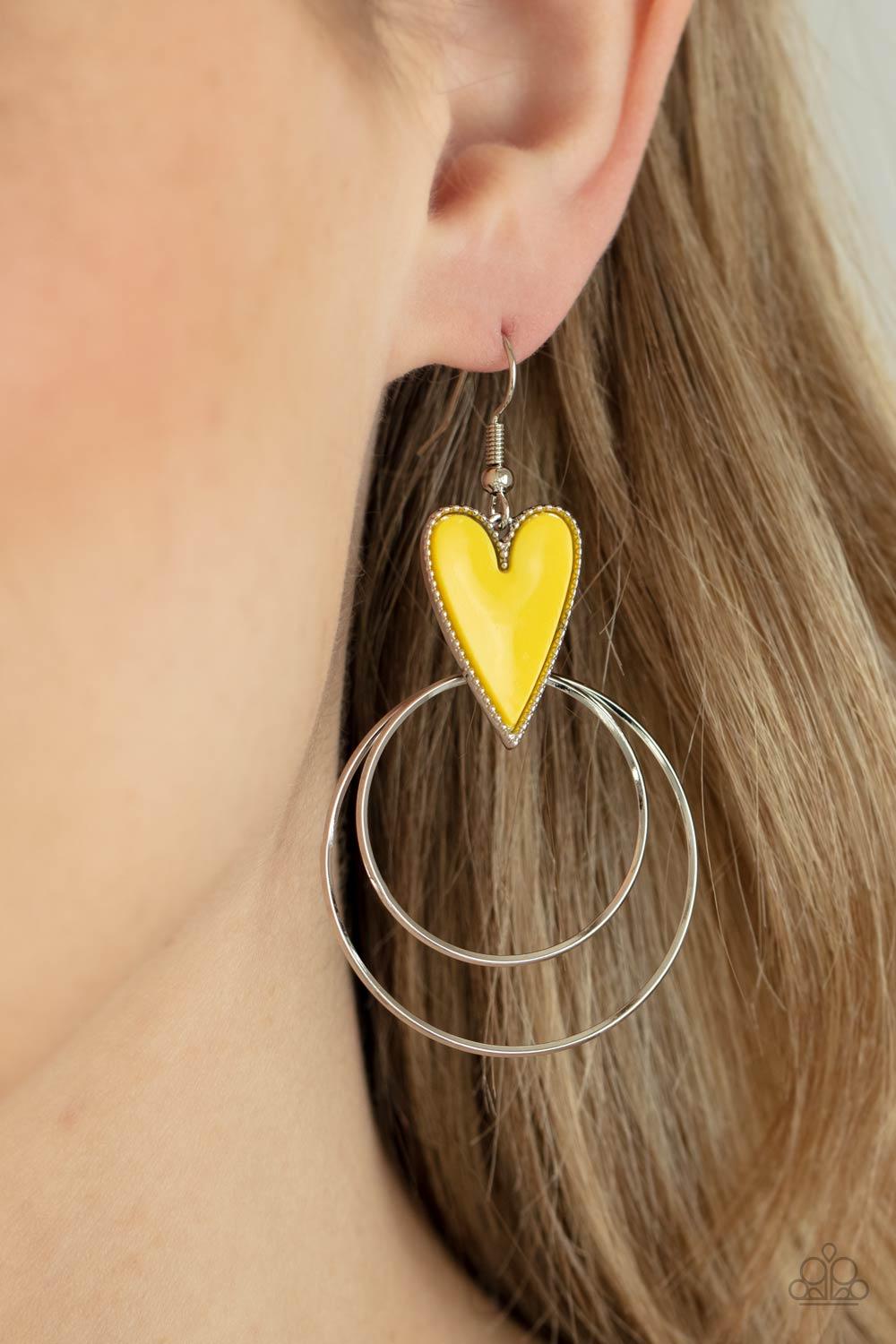Paparazzi Accessories Happily Ever Hearts - Yellow Dainty silver hoops attach to the bottom of a playful Illuminating heart frame, creating a flirtatious pop of color. Earring attaches to a standard fishhook fitting. Sold as one pair of earrings. Jewelry
