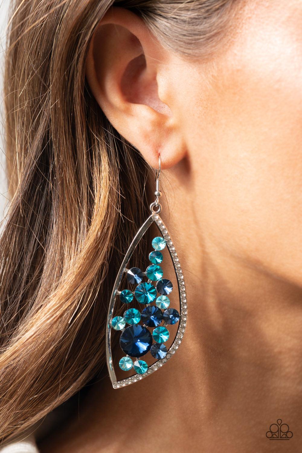 Paparazzi Accessories Sweetly Effervescent - Blue A bubbly collection of light to dark blue rhinestones coalesce inside an asymmetrical silver frame. One side of the frame is encrusted in glassy white rhinestones, adding a refined flair to the bubbly lure