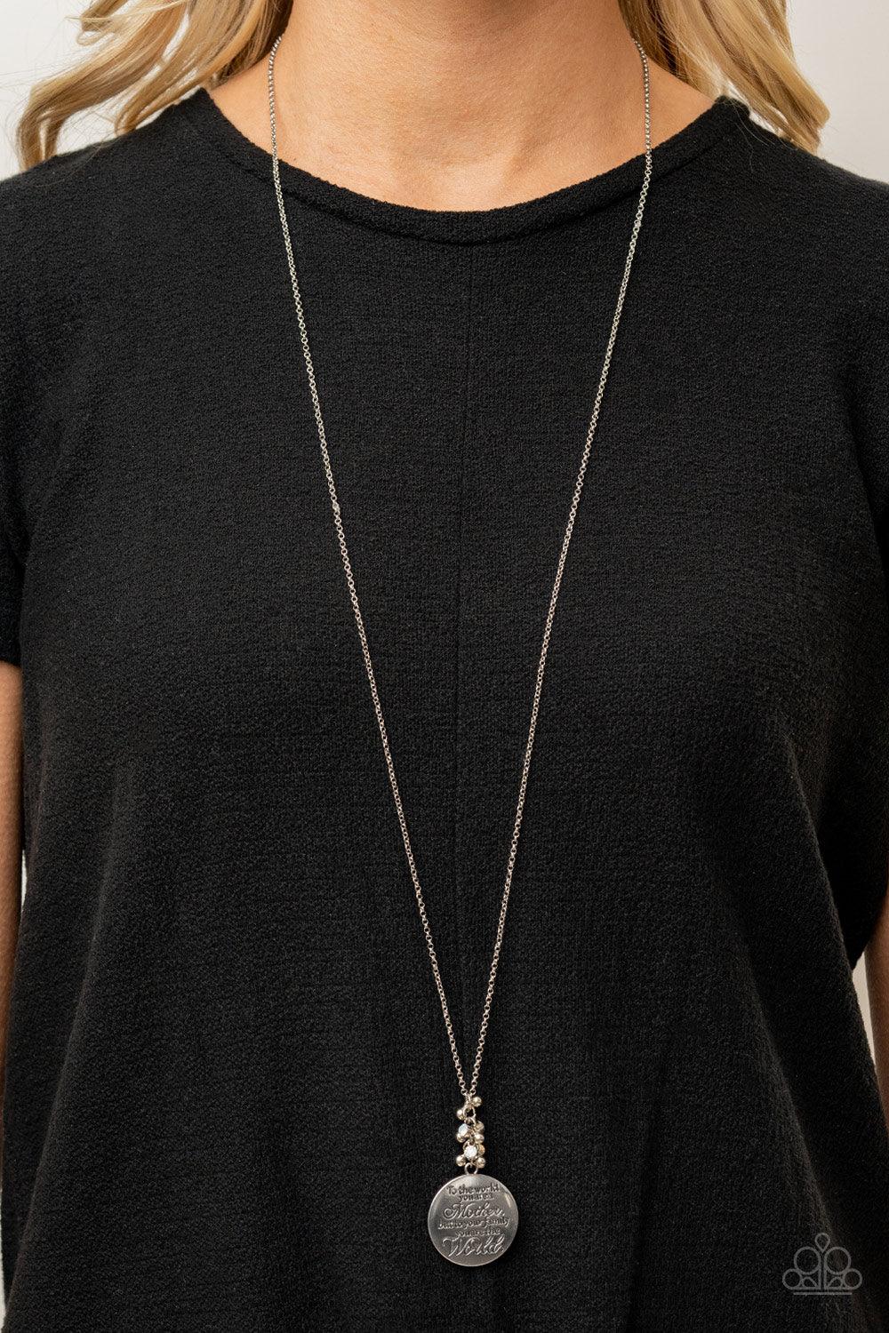 Paparazzi Accessories Maternal Blessings - White A silver disc inscribed with the phrase, "To the world you are a Mother, but to your family you are the World," creates a sweet reminder as it falls from a lengthened silver chain. A sprinkle of dainty whit