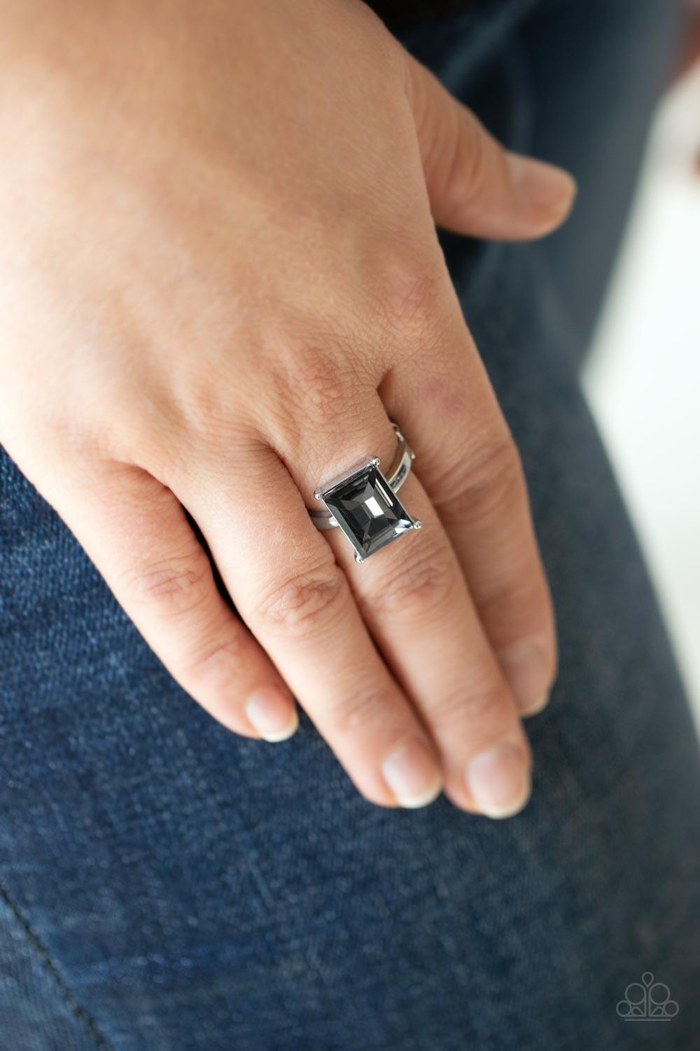 Paparazzi Accessories Social Glow - Silver A smoky emerald cut gem is nestled inside a pronged silver frame atop a dainty silver band, creating a sparkly statement atop the finger. Features a dainty stretchy band for a flexible fit. Sold as one individual