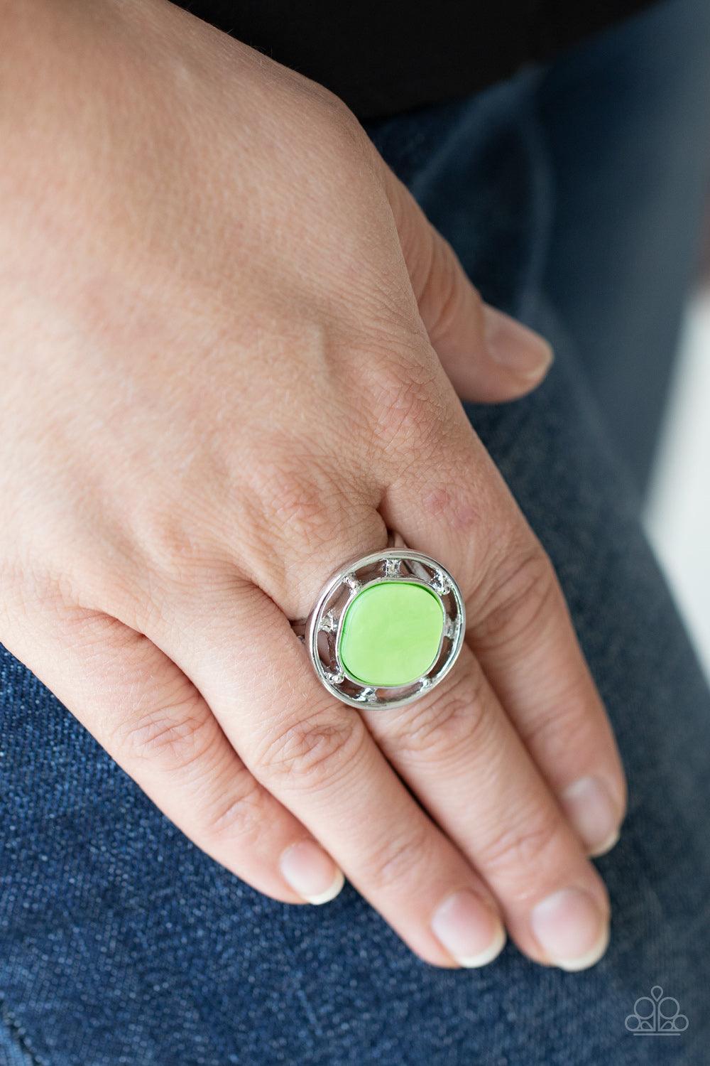 Paparazzi Accessories Encompassing Pearlescence - Green A pearly green square bead, featuring rounded edges, is encircled with an airy silver compass like frame creating a shimmering centerpiece atop the finger. Features a stretchy band for a flexible fit