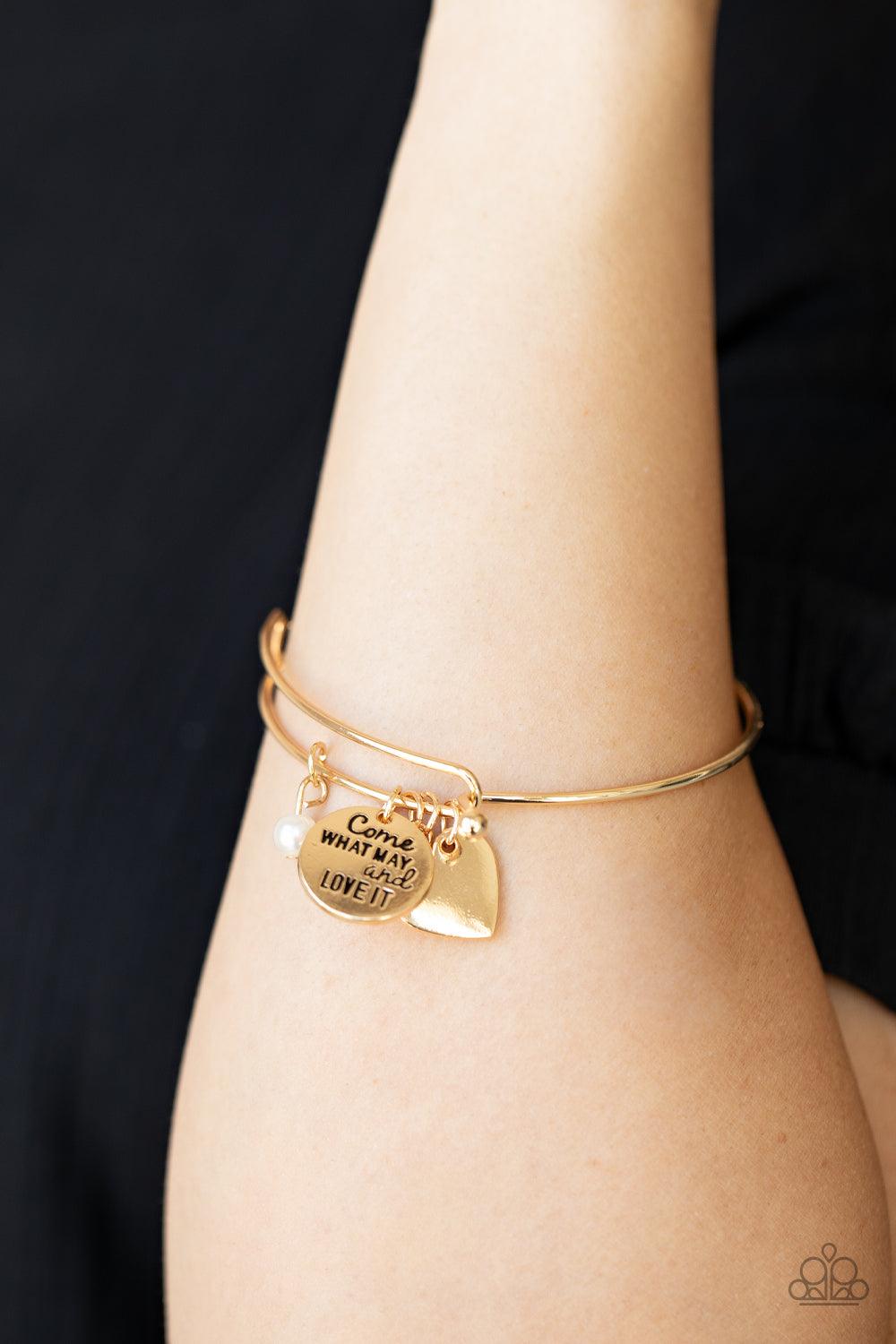 Paparazzi Accessories Come What May and Love It - Gold Infused with a shiny gold heart frame, a dainty gold disc stamped in the phrase, "Come what may and love it," joins pearl, crystal, and rhinestone charms along a bangle-like bracelet for a whimsy look