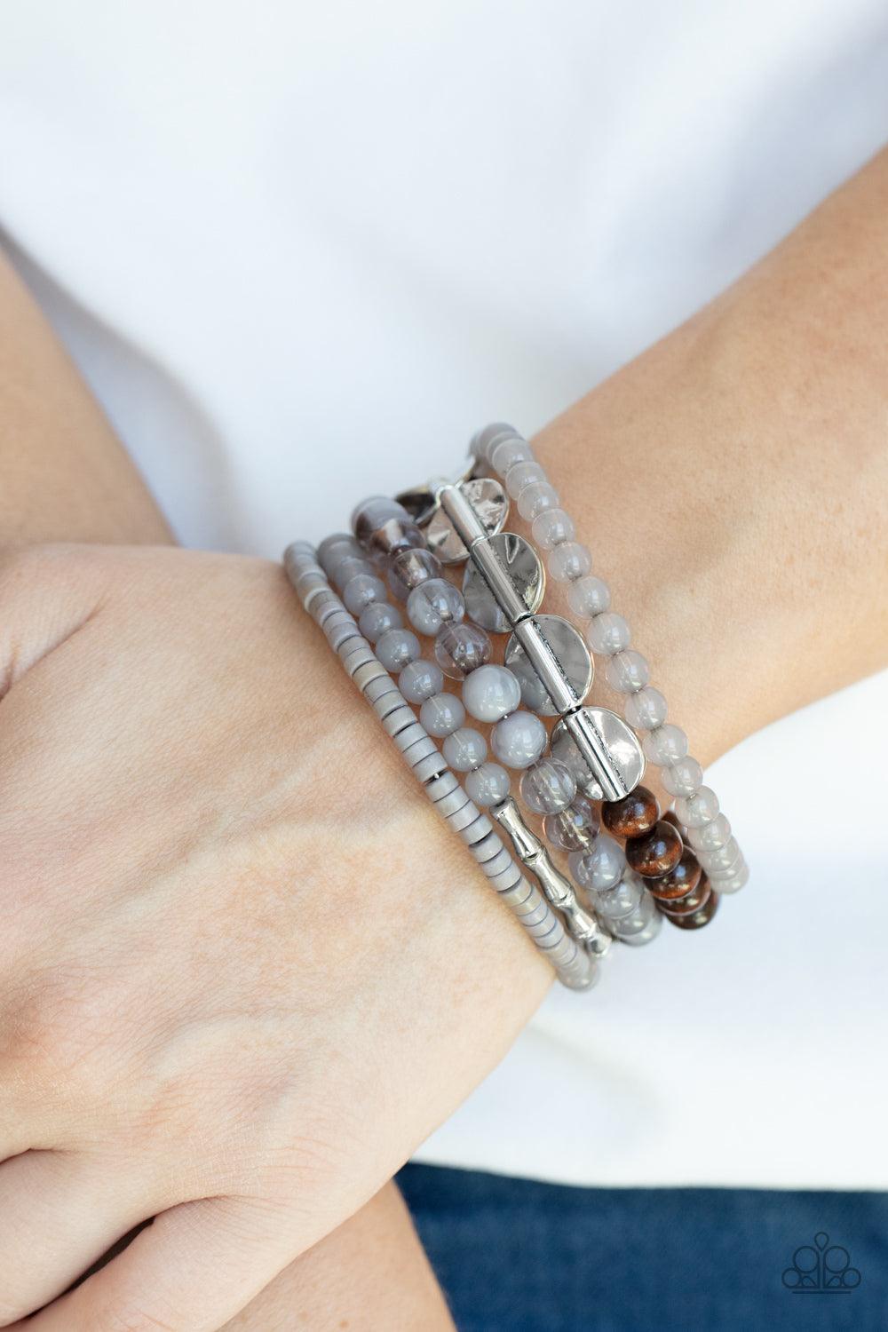 Paparazzi Accessories Free-Spirited Spiral - Silver Mismatched sections of glassy and opaque gray beads join silver discs, brown wooden beads, and gray disc-like beads along a coiled wire, creating an earthy infinity wrap bracelet around the wrist. Sold a