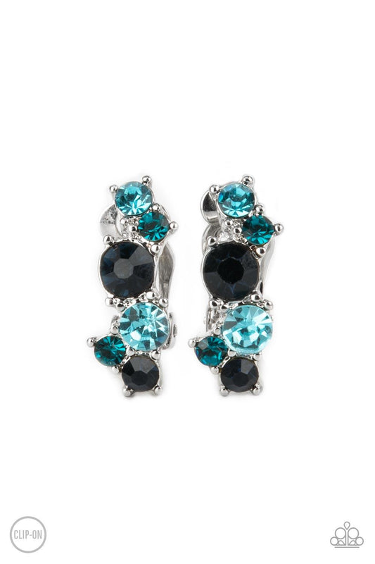 Paparazzi Accessories Cosmic Celebration - Blue Varying in shades of blue, mismatched rhinestones delicately coalesce into a dainty frame for a colorfully sparkly display. Earring attaches to a standard clip-on fitting. Sold as one pair of clip-on earring