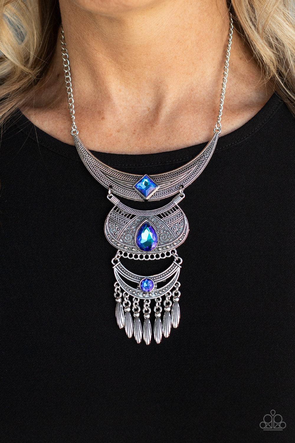 Paparazzi Accessories Lunar Enchantment - Blue Embossed in studded, geometric, and paisley filigree-like patterns, three mismatched silver half moon plates dramatically link below the collar. Featuring an entrancing blue UV shimmer, an oversized collectio