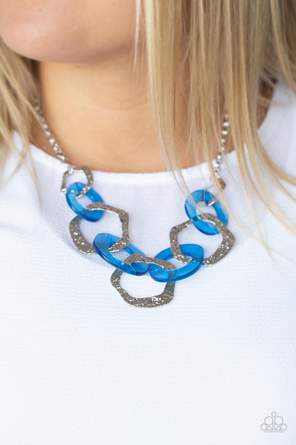 Paparazzi Accessories Urban Circus - Blue An asymmetrical assortment of neon blue acrylic rings and hammered silver hoops boldly interlock below the collar, creating an intense pop of color. Features an adjustable clasp closure. Sold as one individual nec