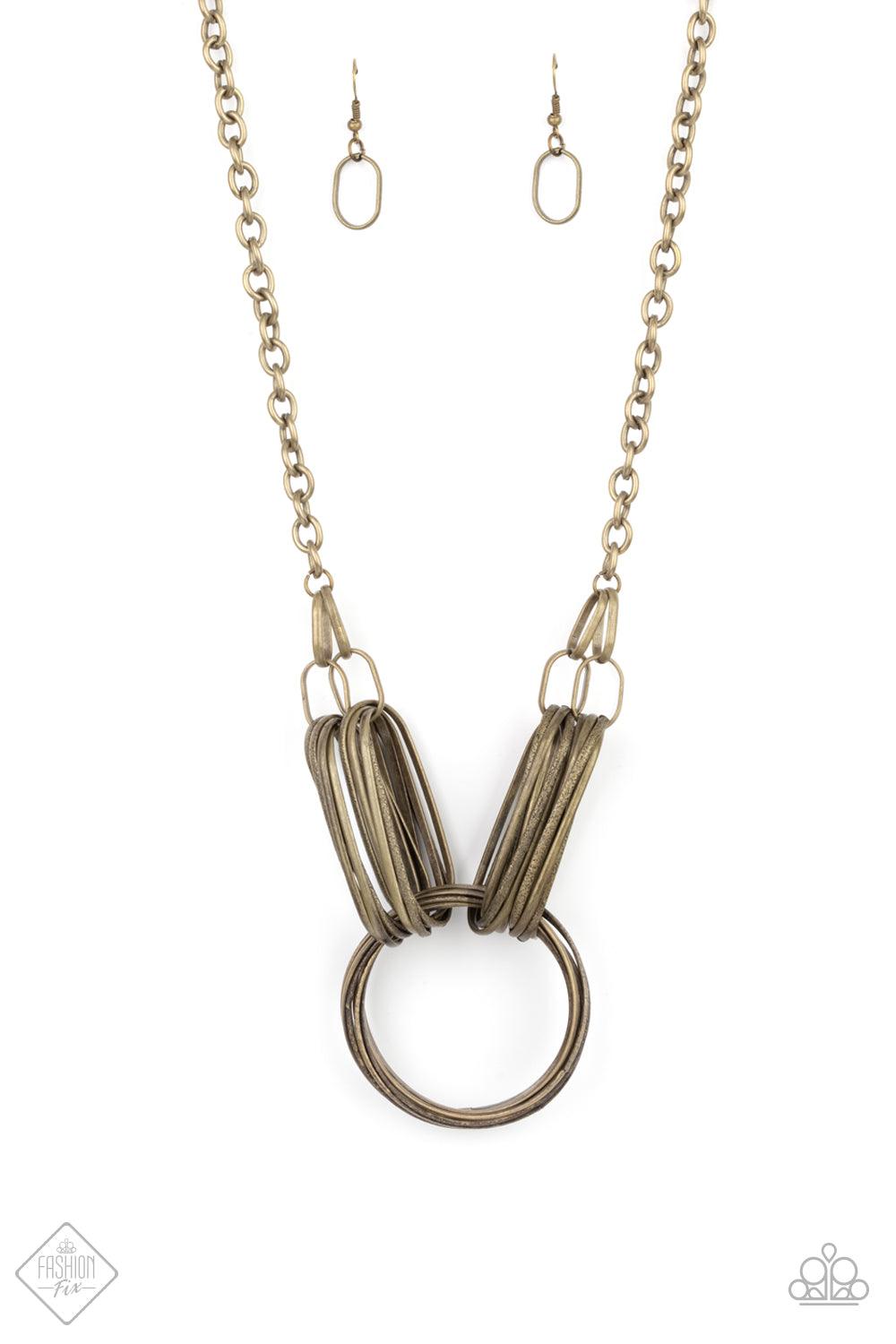 Paparazzi Accessories Lip Sync Links - Brass Layers of oblong brass links attach to a collection of oversized antiqued brass rings creating a dramatic industrial centerpiece. Attached to a brass chain, the rustic links create an unconventionally edgy stat