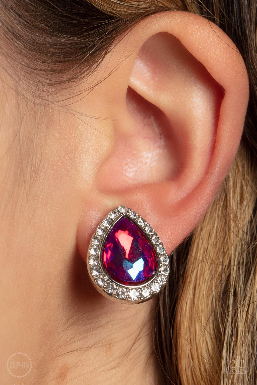 Paparazzi Accessories Cosmic Castles - Pink *Clip-On Featuring a flashy UV finish, a faceted pink teardrop gem is pressed into a silver frame bordered with glittery white rhinestones for a glamorous finish. Earring attaches to a standard clip-on fitting.