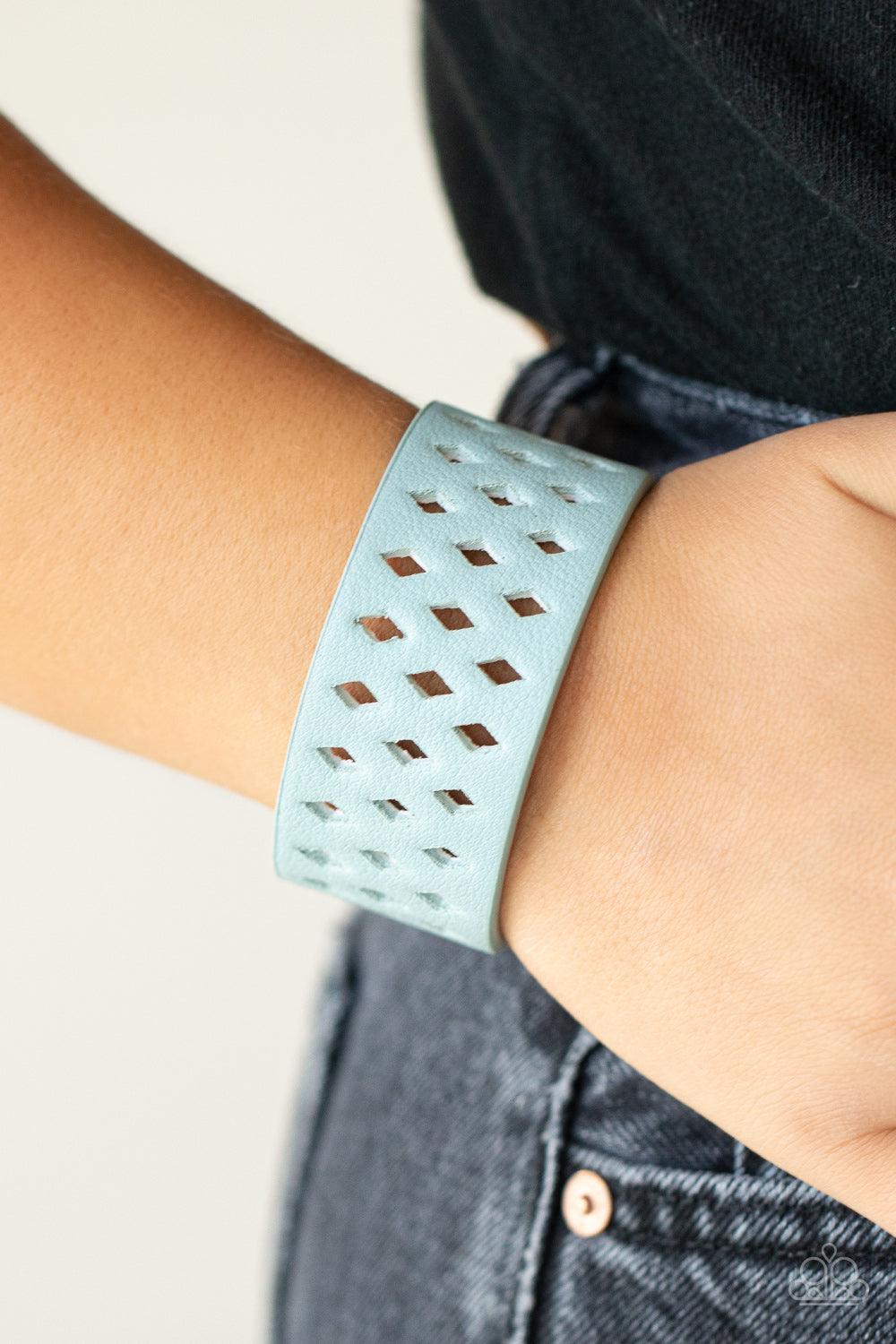 Paparazzi Accessories Glamp Champ - Blue A wide blue leather band is filled with patterned rows of small diamond-shaped cutouts giving the illusion of diamonds floating across the wrist in a whimsical fashion. Features an adjustable snap closure. Sold as