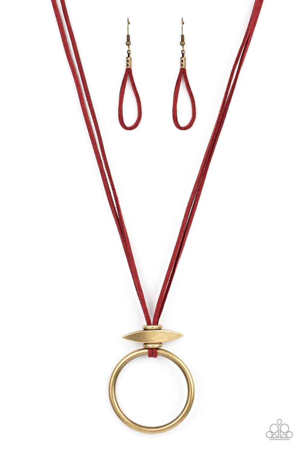 Paparazzi Accessories Noticeably Nomad - Red Flanked by dainty brass rings, a marquise shaped brass bead glides along lengthened strands of rustic red suede, holding in place an oversized brass ring at the bottom for an artisan inspired fashion. Features