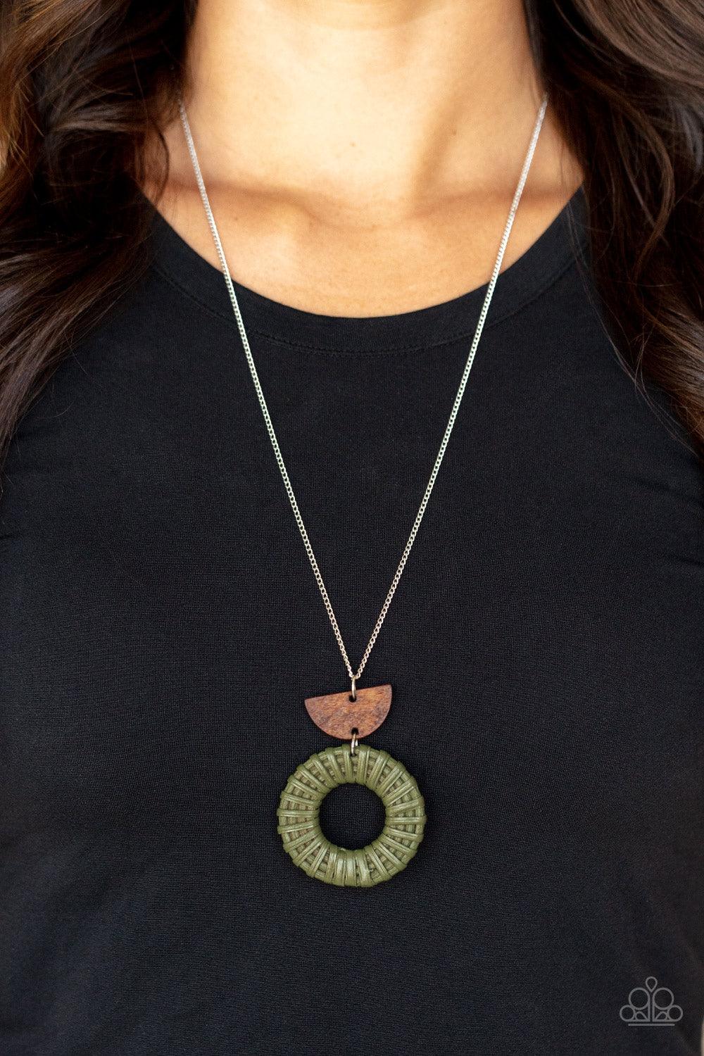 Paparazzi Accessories Homespun Stylist - Green Green wicker-like cording wraps into a rustic hoop at the bottom of a half-moon wooden frame. The earthy stacked pendants swing from a lengthened silver chain, creating an artisan-inspired display. Features a