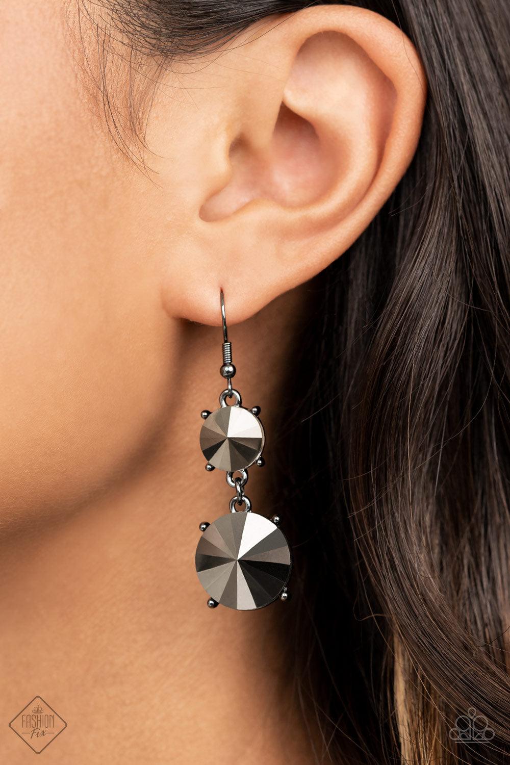 Paparazzi Accessories Sizzling Showcase - Black Featuring pronged gunmetal fittings, two oversized hematite rhinestones dramatically link into a bold smoldering lure as they drip dazzlingly from the ear. Earring attaches to a standard fishhook fitting. So