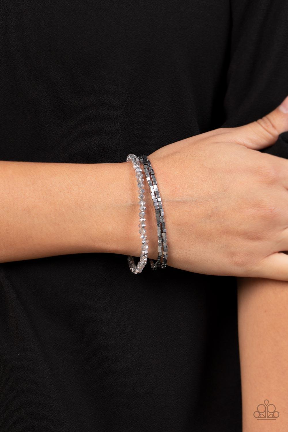Paparazzi Accessories Just a Spritz - Silver Two rows of dainty silver cube beads and one row of smoky crystal-like beads are threaded along stretchy bands around the wrist, creating stellar layers. Sold as one set of three bracelets. Jewelry