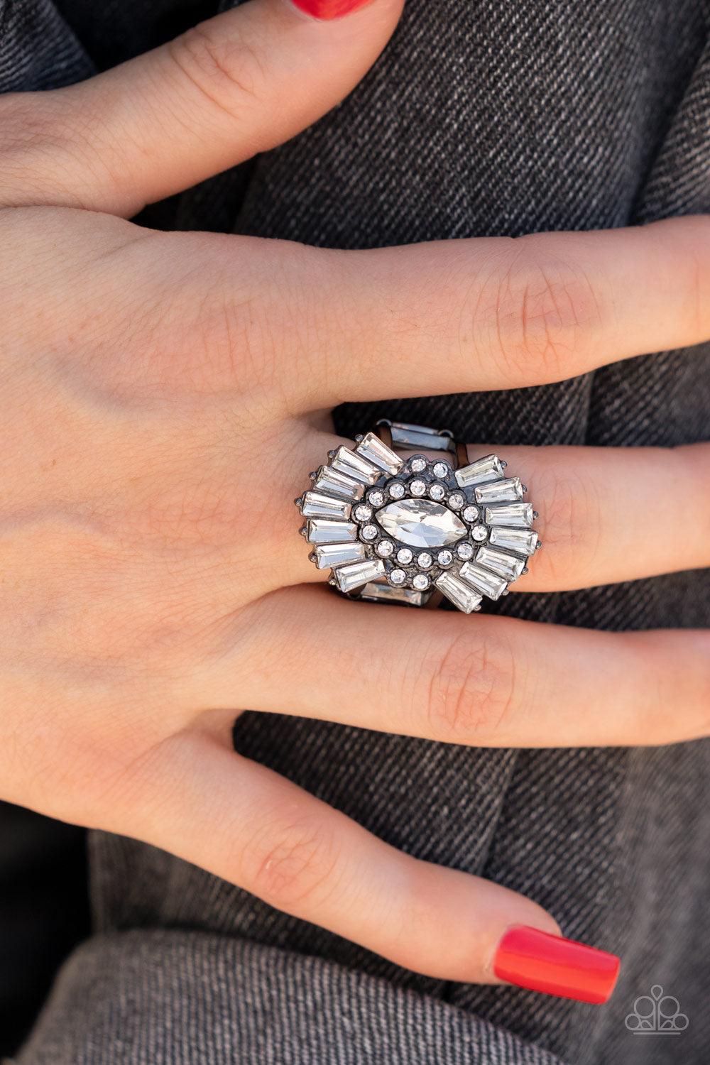 Paparazzi Accessories Daringly Deco - Black A white, marquise-cut rhinestone is bordered in glassy white rhinestones atop fans of trapezoidal-cut white rhinestones, resulting in an edgy sparkle that explodes atop the finger. Features a stretchy band for a
